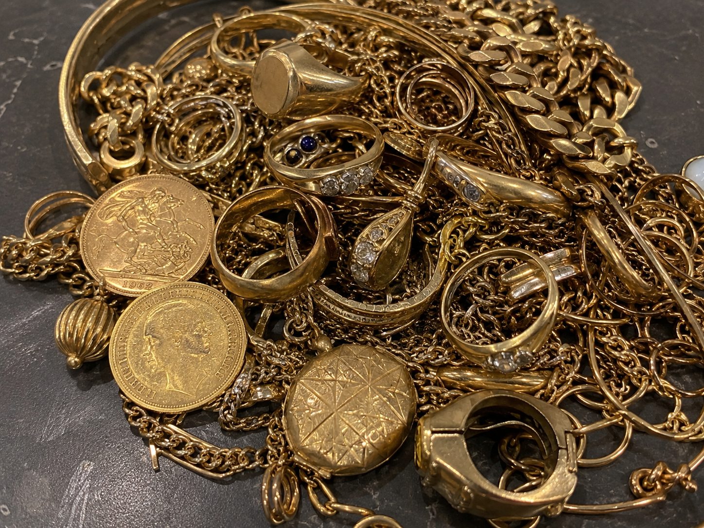 A pile of gold jewellery, chains, rings and coins ready for valuation